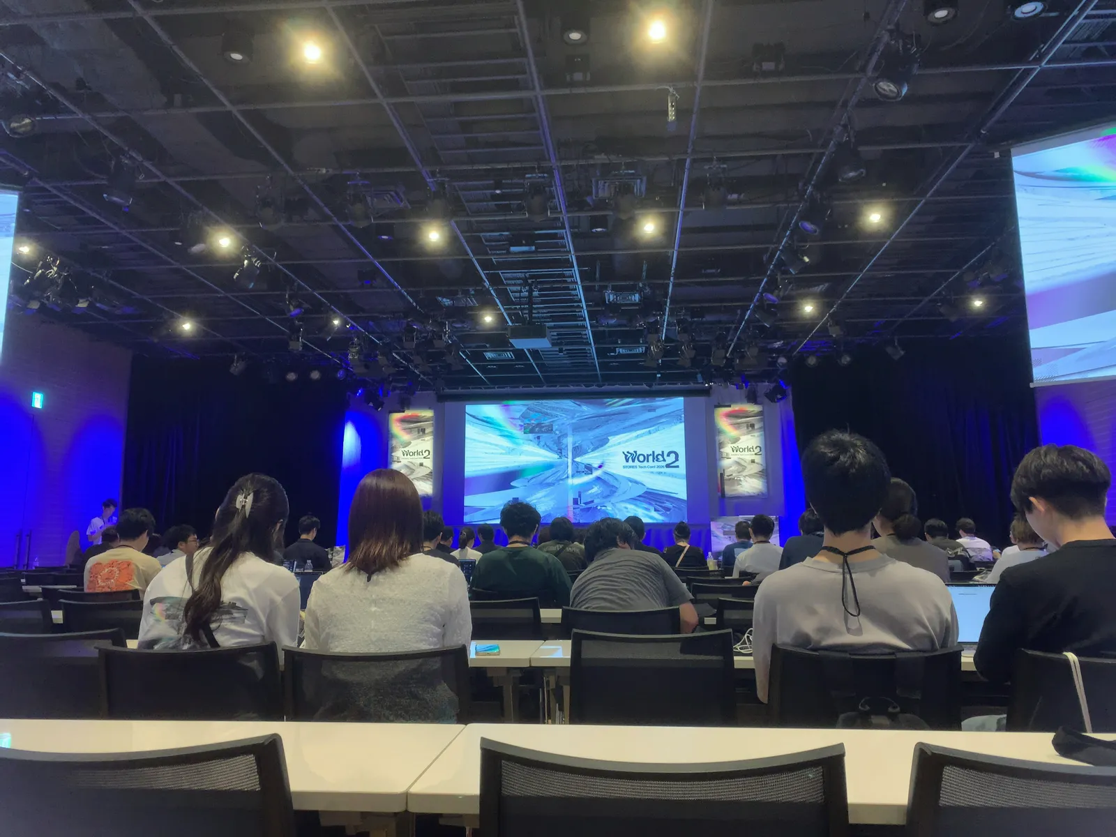 開演前の会場。ステージ大画面に World 2 のキービジュアル